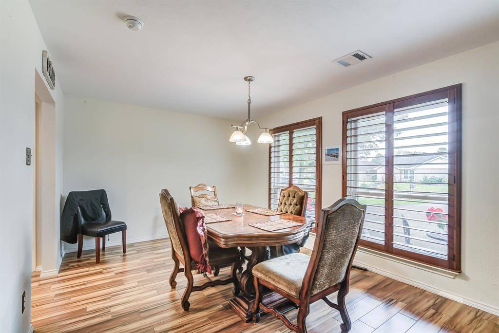 Bright dining area with  large windows and shutters creating a warm and inviting space.