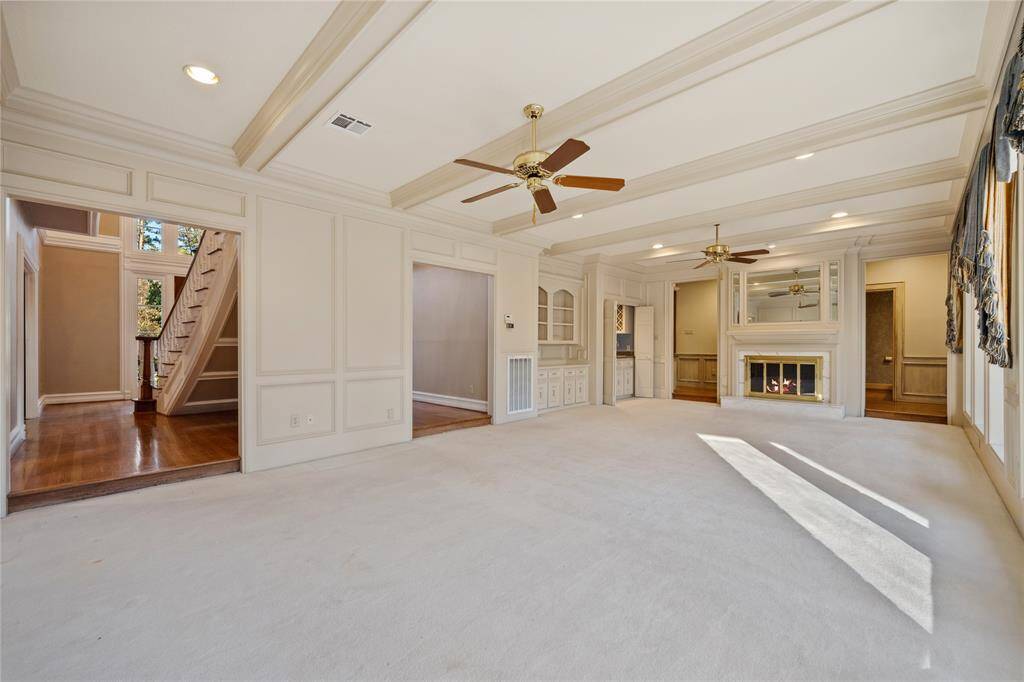 Another view of the large living area downstairs... wet bar and built-in storage... beamed ceiling...