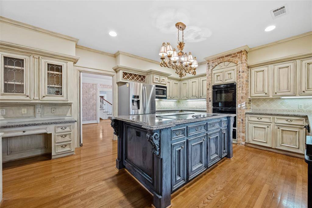 Wood floors... Double ovens... E stove in Island... leaded glass in doors over the desk area...