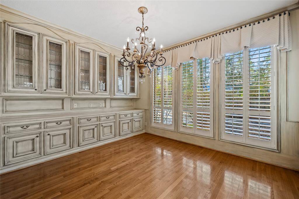 This is thier "BREAKFAST AREA" ... Plantation Shutters... Magnificent cabinetry with glass doors... Wood floors... (what a great room to play cards in!