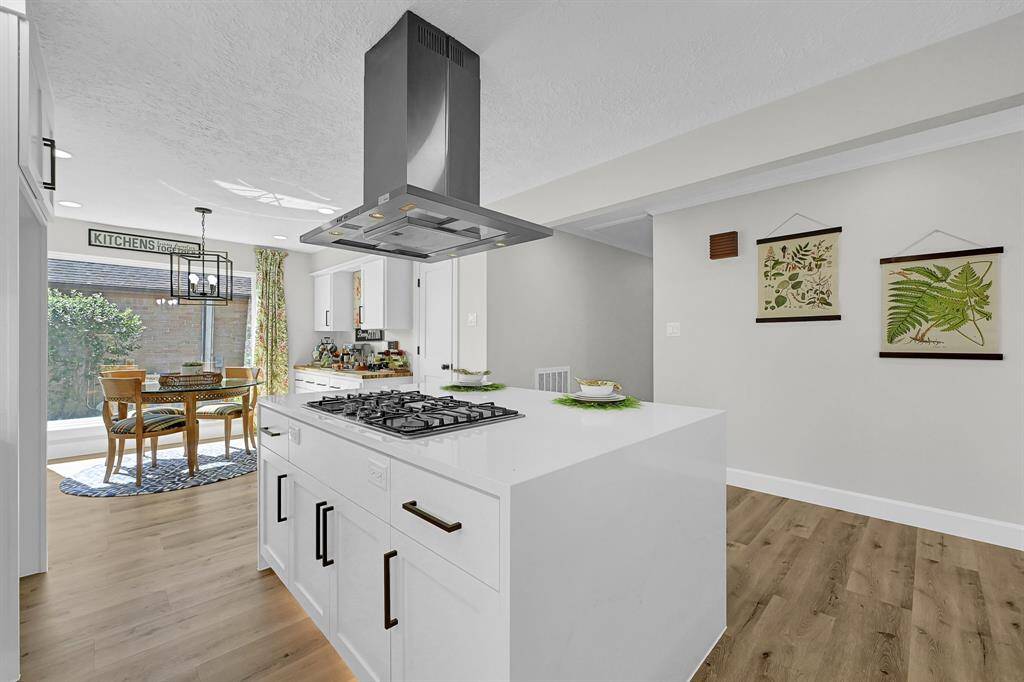 This stunning waterfall island serves as the centerpiece of the kitchen, featuring sleek quartz countertops and ample storage for a modern, functional design. A newly installed gas line allows for the high-performance gas cooktop, enhancing both cooking efficiency and style.