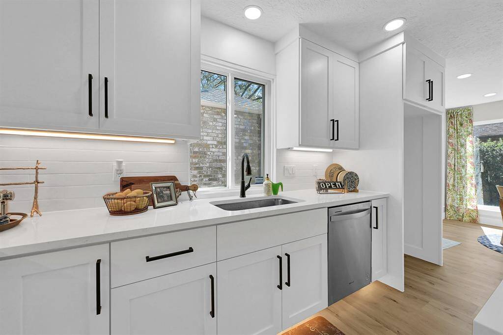 This beautifully designed kitchen sink area features a modern black faucet, sleek quartz countertops, and a large window that fills the space with natural light. Enhanced with under-cabinet lighting and custom cabinetry, this space blends style and functionality for an elegant culinary experience.This beautifully designed kitchen sink area features a modern black faucet, sleek quartz countertops, and a large window that fills the space with natural light. Enhanced with under-cabinet lighting a