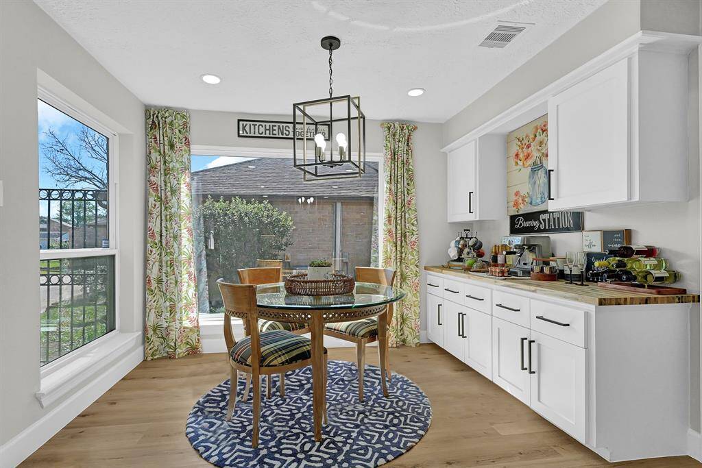 This charming breakfast nook features a stunning picturama window, flooding the space with natural light and offering beautiful outdoor views. The newly installed butcher block butler pantry serves as a versatile coffee station, wet bar, or meal-serving area, adding both style and functionality to this inviting space.
