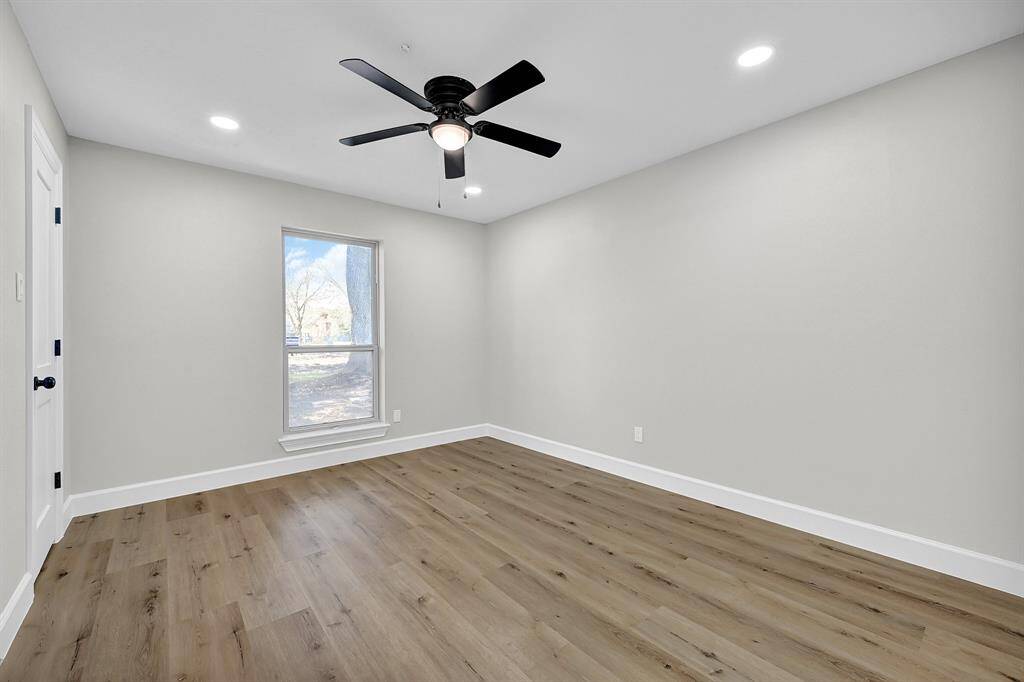 This generous bedroom offers plenty of space to create a restful retreat, with a large window framing a peaceful view of the yard. The luxury vinyl plank floor is both sturdy and visually appealing, mimicking the look of hardwood while being easy to maintain.