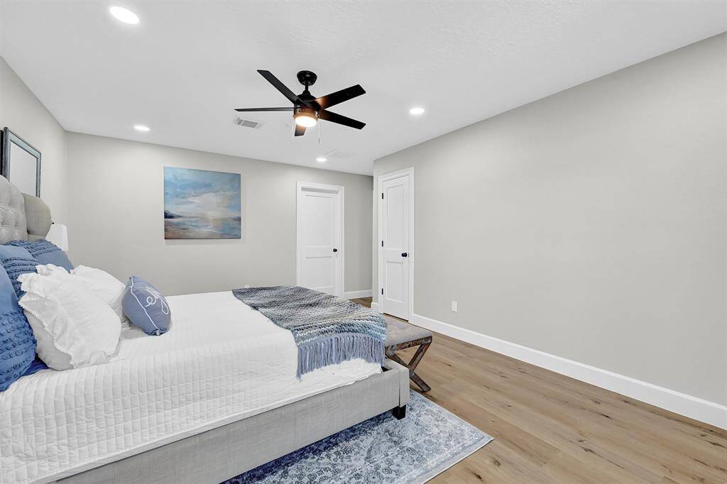 This spacious master bedroom features a private ensuite bathroom through the left door, offering a luxurious retreat. The additional storage closet provides ample space for coats, gowns, or special occasion wardrobe, adding convenience and functionality to the room.
