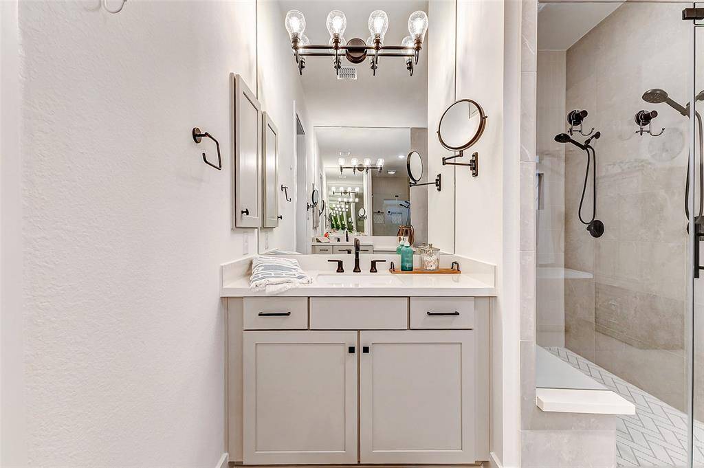 Wash away the day in a shower built for two! Beautiful penny tile in warm neutral chevron pattern, large bench and seamless glass make this a true haven.