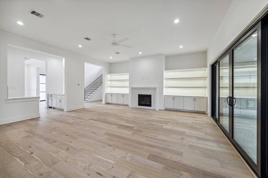 Family Room toward wet bar to the left and stairwell / foyer. Room is prewired for surround sound speakers and HDTV drop with soundbar prewire above fireplace.