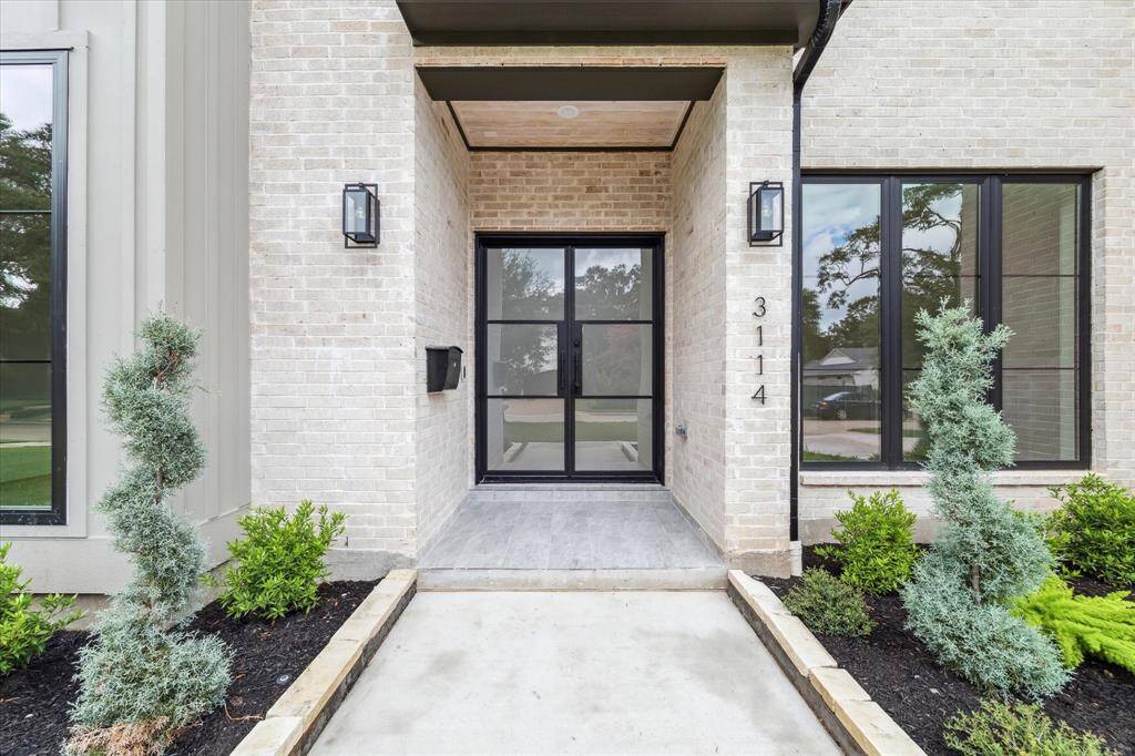 Gracious entry with frosted glass, custom iron doors and video doorbell.