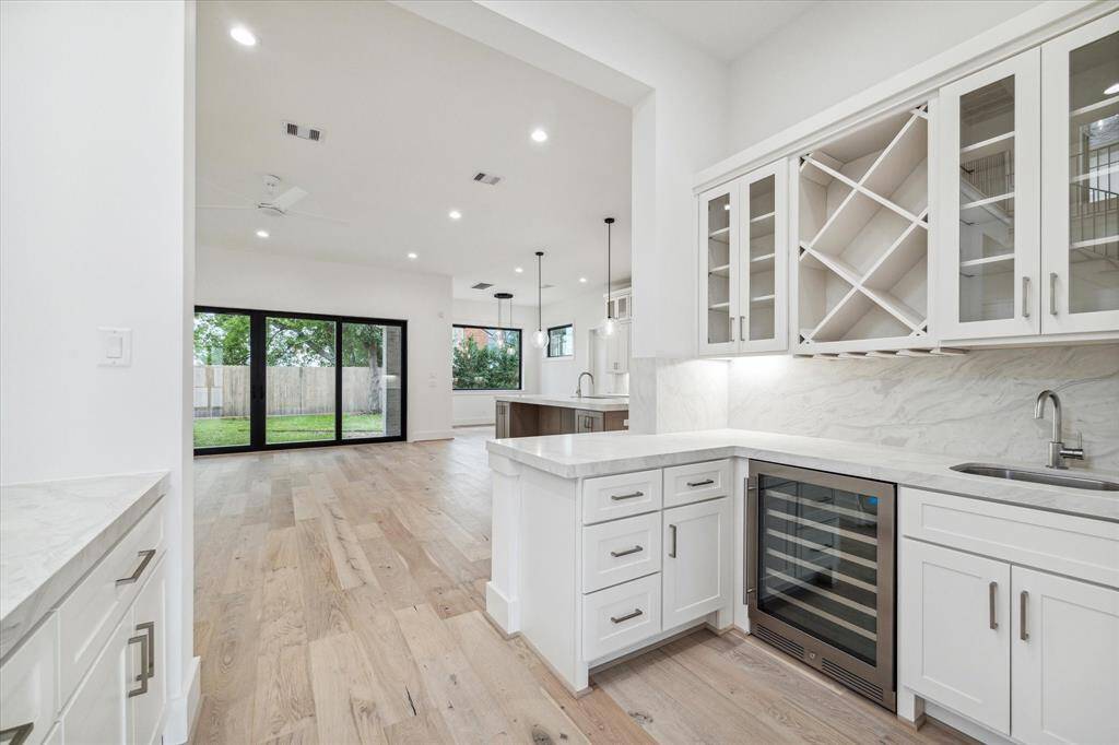 Quarts counter wet bar / butler's pantry between family room / kitchen and dining room includes wine / beverage refrigerator and ice maker.