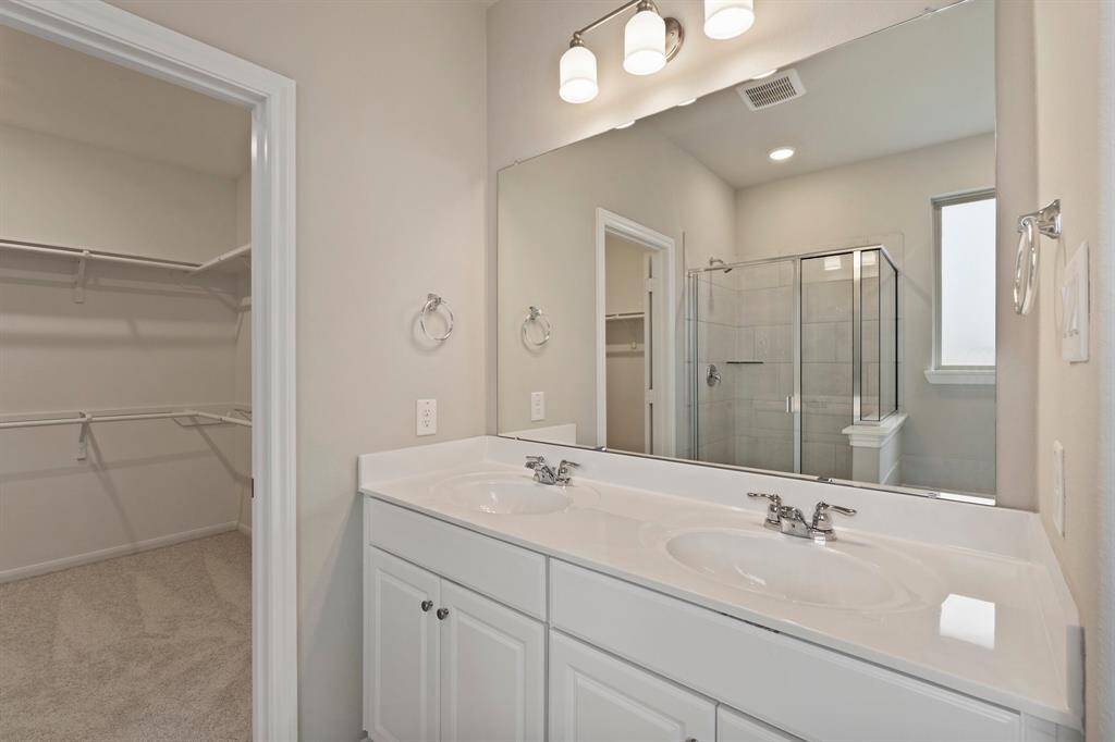 The en-suite bathroom offers a spa-like atmosphere with its elegant design, high end finishes, and tasteful lighting, creating a retreat within your own home.