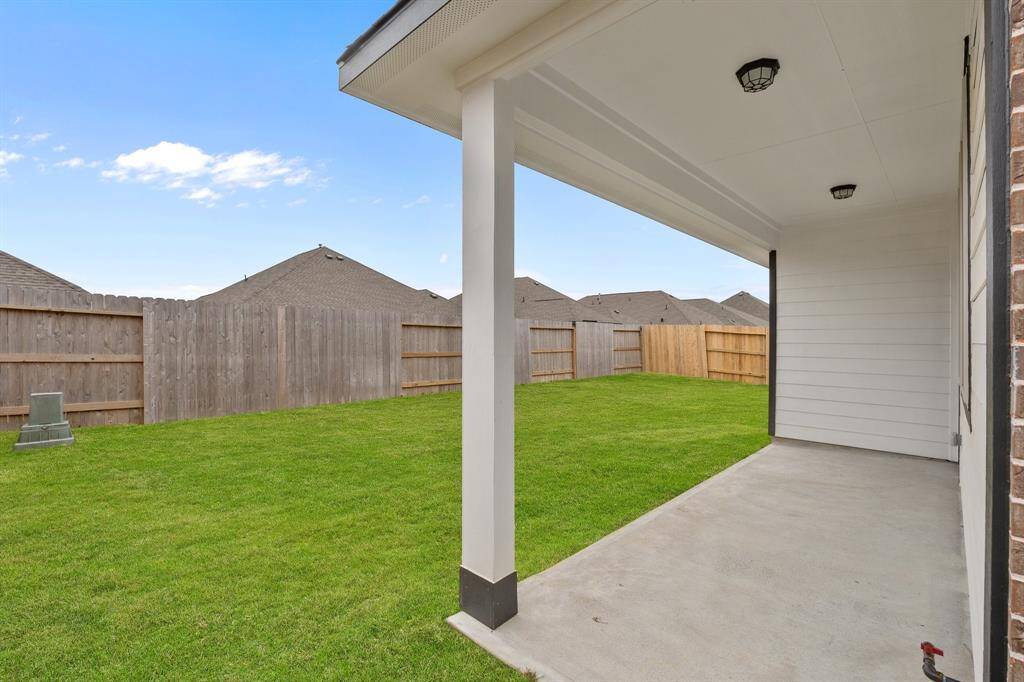 The covered patio is generously sized, providing ample space for various outdoor activities.