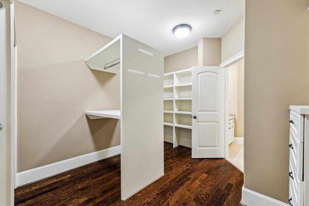 The expansive walk-in closet adjoins the primary bath and is outfitted with built-ins and ample shelving, providing plenty of storage and organization.