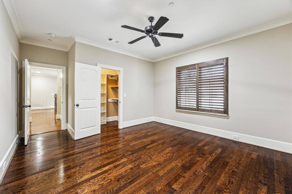 Secondary bedroom offers hardwood floors, a window with plantation shutters overlooking the front of home, 9’ ceiling with fan, walk-in closet, and Ensuite bath with granite vanity and tub/shower combo with sliding glass door.