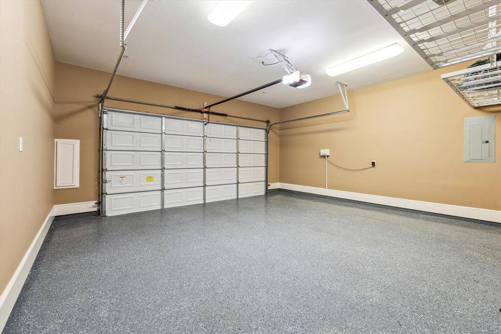 Double-wide leads to attached two-car garage; features an epoxy-coated floor (2024) and ample overhead storage.