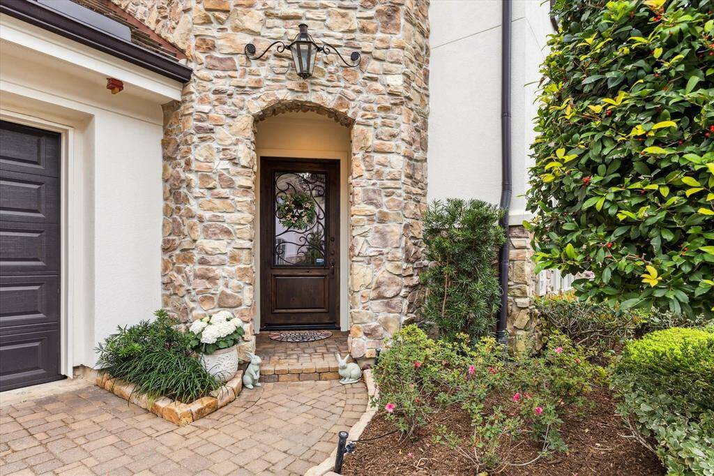 The arched entryway, framed by intricate wrought iron detailing, welcomes you into a space of sophistication and timeless design.