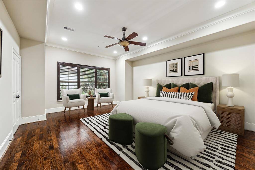 Upstairs, the spacious primary suite features rich hardwood floors, a 10’2” tray ceiling with a ceiling fan, and large windows with plantation shutters overlooking the backyard. Double doors open to a well-appointed bath, creating a relaxing retreat. This photo has been virtually staged.