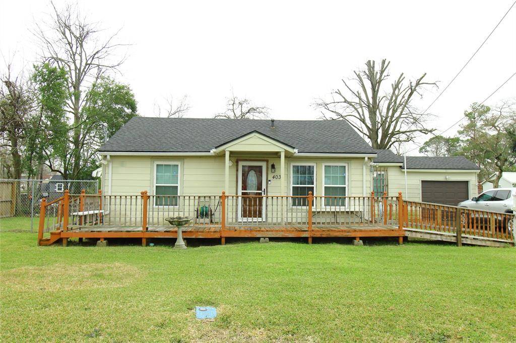 Charming single-story home with a welcoming front porch and wheelchair-accessible ramp. It features a fenced yard, detached garage, and mature trees, offering a cozy and convenient living space.
