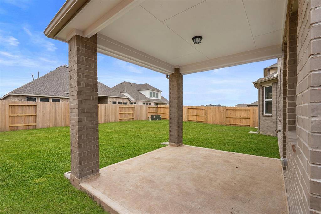 The covered patio is generously sized, providing ample space for various outdoor activities.