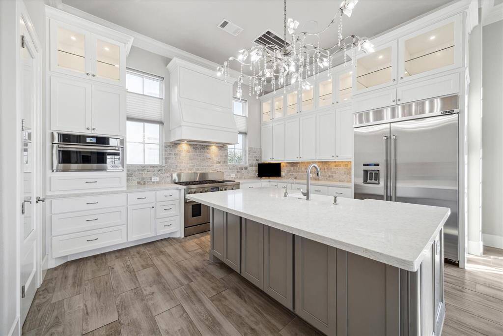 Jen-Air professional grade appliances include built-in refrigerator, double ovens, 6 burner 48" range with griddle and convection microwave.