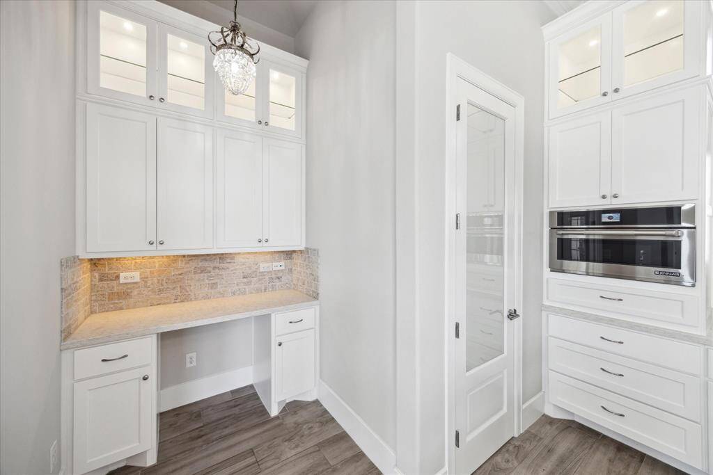 Large walk-in pantry and adjoining day desk.  Custom pantry features coffee bar with additional cabinetry, dedicated filtered water tap.