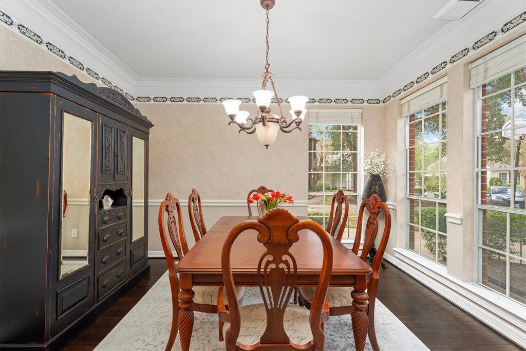 Elegant dining space with rich hardwood floors and sophisticated crown molding, perfect for hosting memorable gatherings.