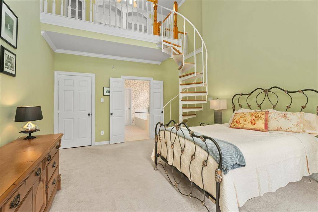 Step into the serene primary suite, featuring direct access to a luxurious en-suite bathroom through elegant double doors, complemented by a unique loft space accessible via a charming spiral staircase.