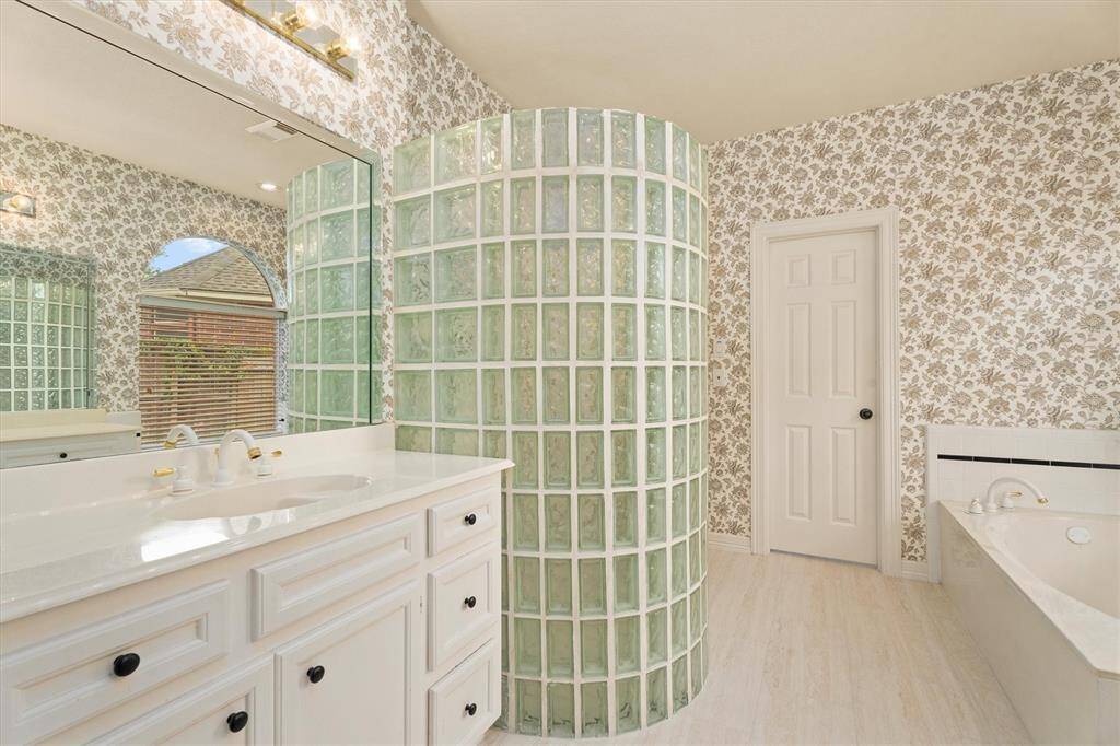 Step into the elegance of your updated primary bathroom, complete with newly installed, sleek floor tiling, a luxurious soaking tub, and a separate, spacious shower enclosure for the ultimate relaxation experience.