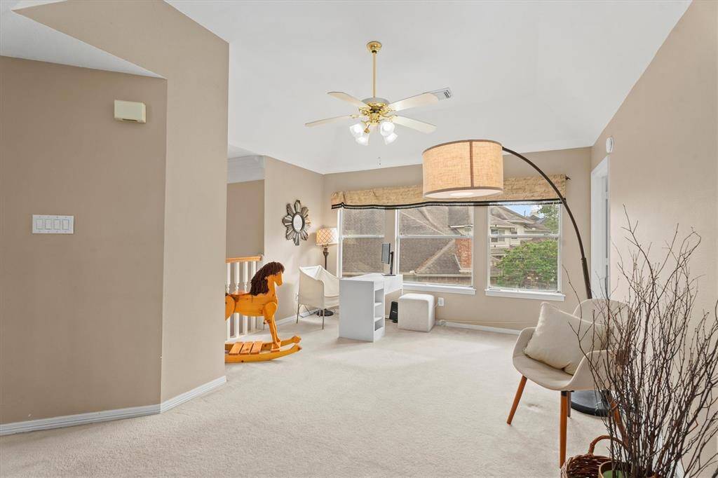 Step up to an inviting, sunlit game room, boasting expansive windows that offer natural light and an airy ambiance.