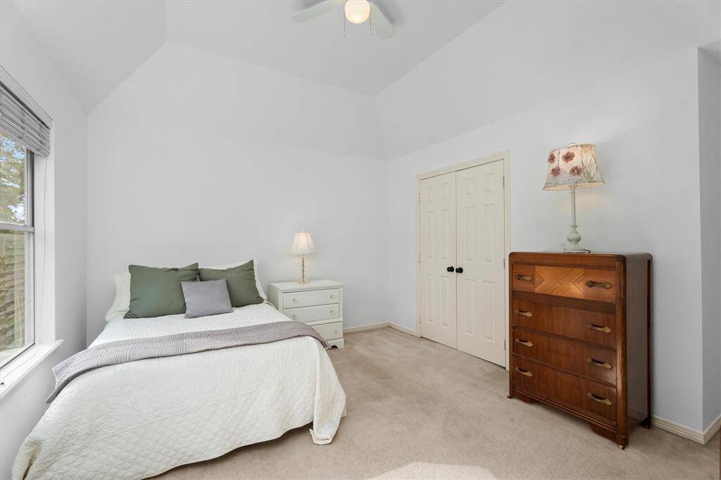 Charming secondary bedroom facing the backyard featuring spacious dual-door closet and two convenient entryways, offering versatile access and ample storage.