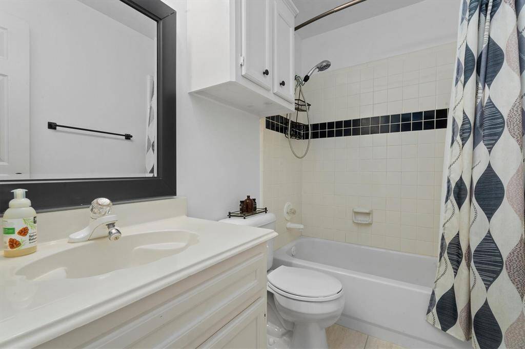 Discover the elegance of the refreshed en-suite bathroom, boasting chic black and white tiling that perfectly complements the modern shower and tub enclosure.