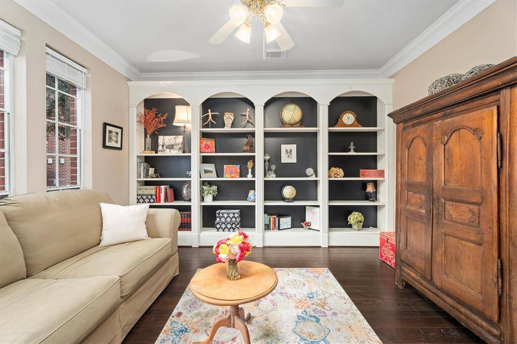 Discover the elegance of this home office with sophisticated crown molding, a modern ceiling fan, hard wood flooring and a serene view overlooking the front landscape. This office space has french doors, plus looks out to the front of ther home.  Your going to love working from home.