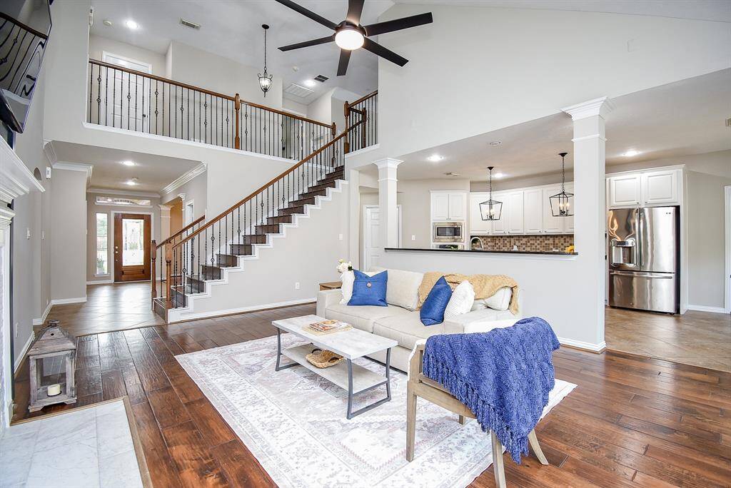 The rich hardwood floors and neutral wall tones provide warmth and versatility, while the vaulted ceiling and modern fan add a touch of sophistication.