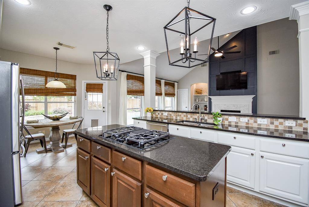 The kitchen overlooks the living area, boasting a sleek, open bar design, stainless steel appliances, and plenty of cabinets and counter space.