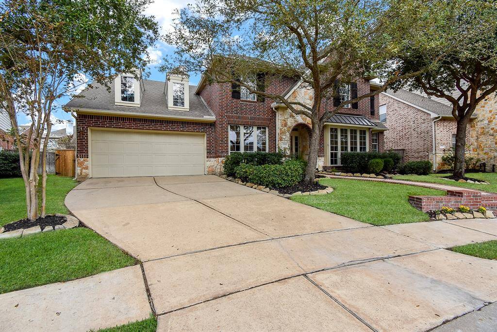 The home’s inviting curb appeal is enhanced by a charming brick and stone exterior, mature trees, and meticulously maintained landscaping.