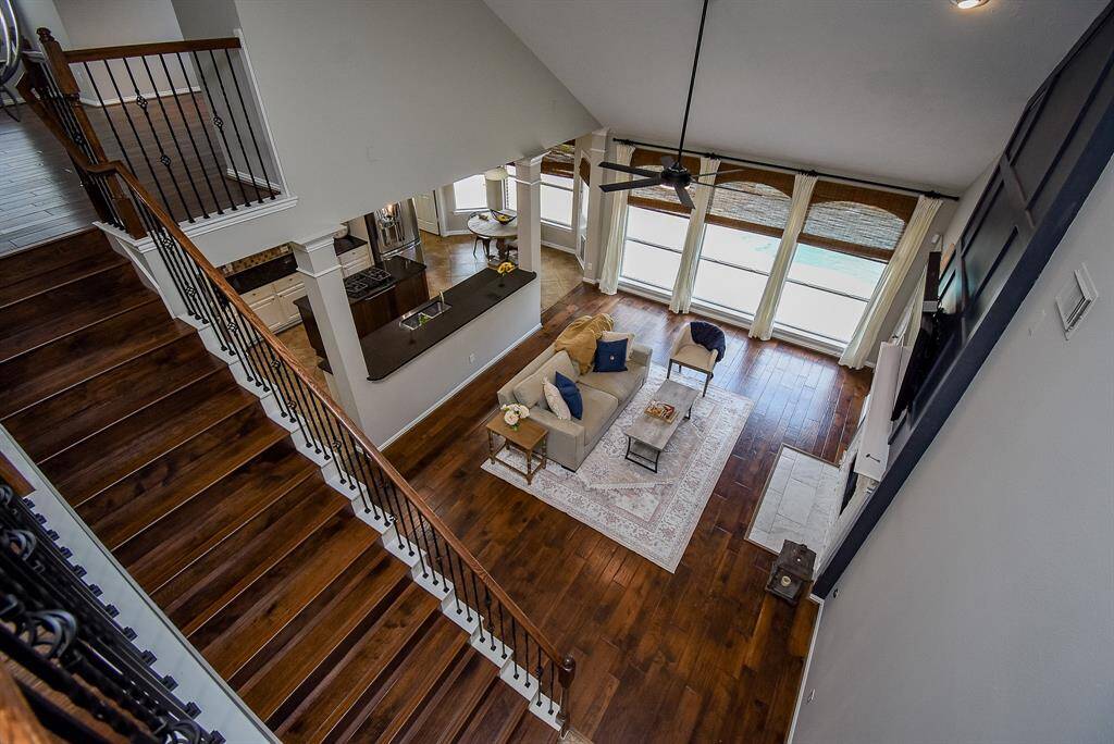The open floor plan seamlessly integrates the dining and kitchen areas, while the wrought-iron staircase and hardwood floors add a touch of luxury and warmth.
