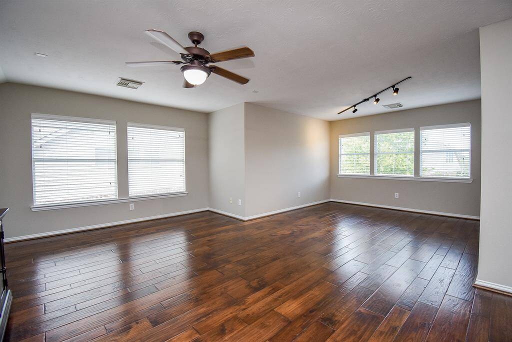 With gleaming hardwood floors, ample natural light from large windows, and neutral tones, this space is a blank canvas for entertainment or relaxation.