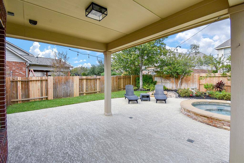 The covered patio provides a shaded retreat for relaxing or entertaining.