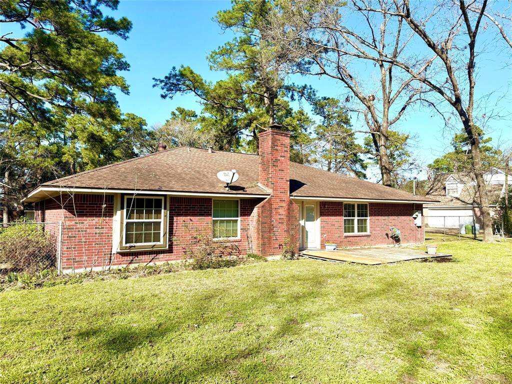 Backyard showing wood deck and wood burning fireplace located family room