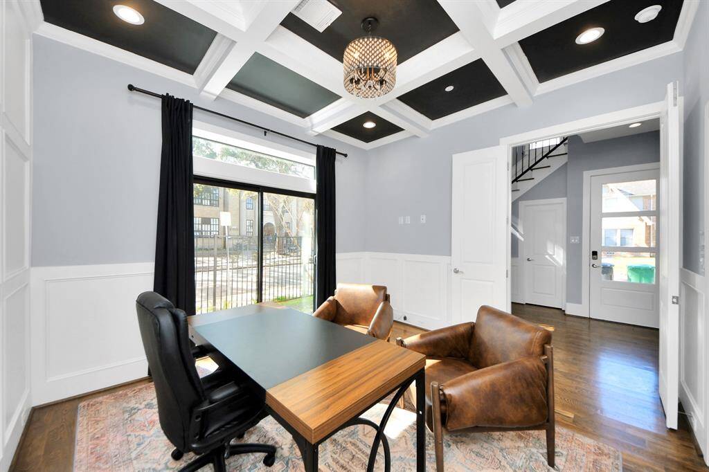 Experience the perfect blend of sophistication and warmth in this home office, boasting elegant wood-look tile flooring and flooded with natural light from expansive windows and French doors.