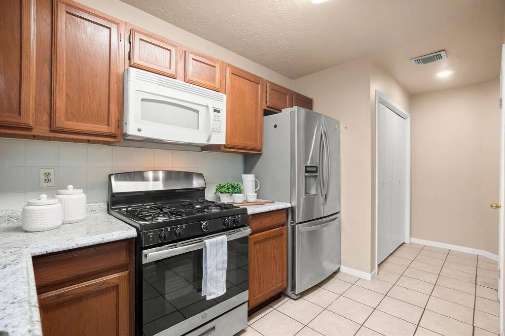 The stainless refrigerator is included, as well as a washer and dryer located to the right the refrigerator