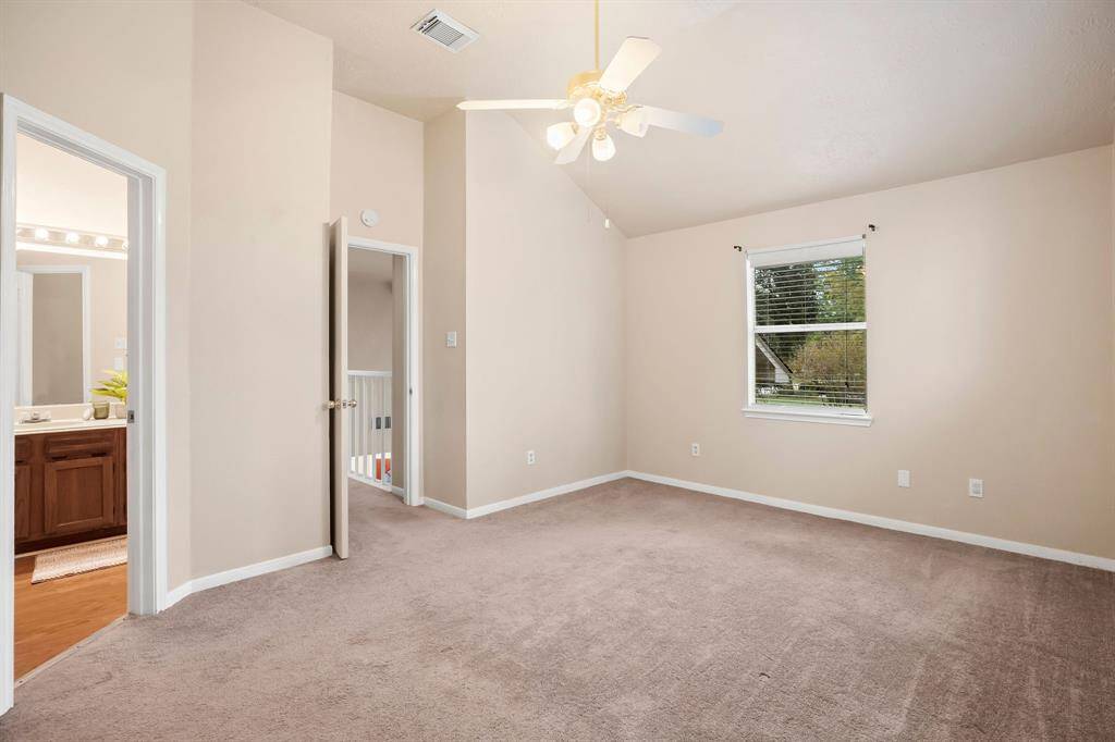 Primary bedroom features a vaulted ceiling
