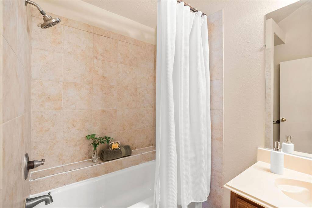 The shower and bath area has a cute shelf for keeping all of your bath products close by