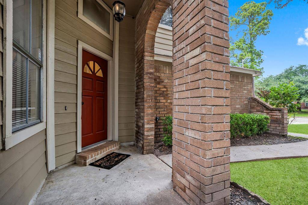 A charming covered entry with red door to welcome you home