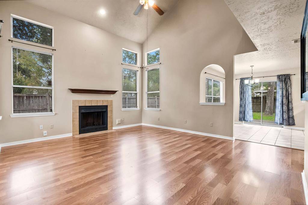 Family room features a vaulted ceiling, ceiling fan and gas fireplace
