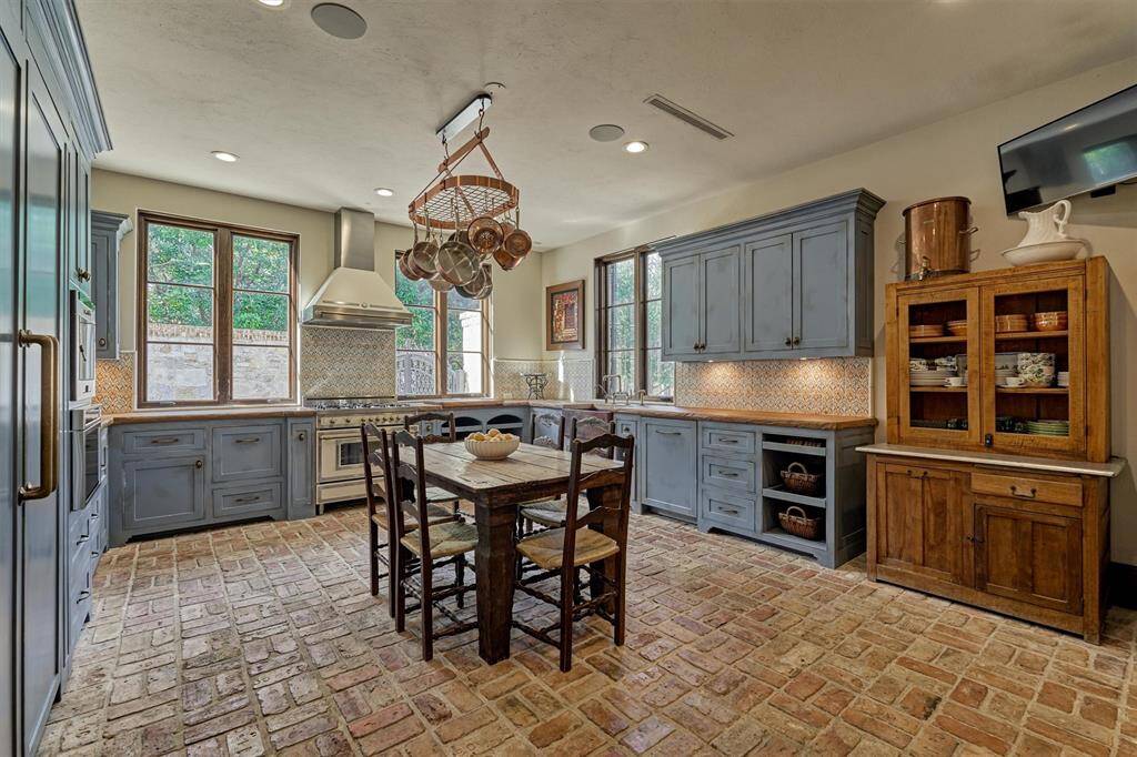 Dirty kitchen, designed to keep main kitchen pristine while handling heavy cooking,  is a traditional Italian-inspired space.  Custom live oak counters,  built-in espresso machine, warming drawer, and another Bertazzoni gas range will delight any culinary enthusiast.