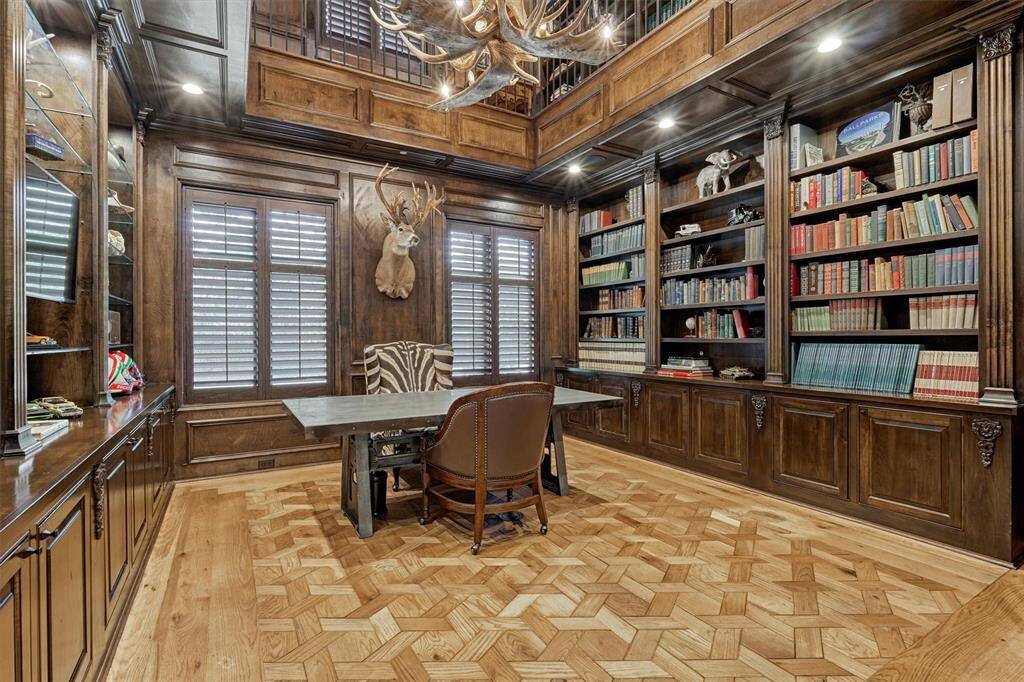 King-sized office enhanced by elegant wood built-ins extends to the upstairs library, accessed by spiral staircase or secret door in second floor hallway.