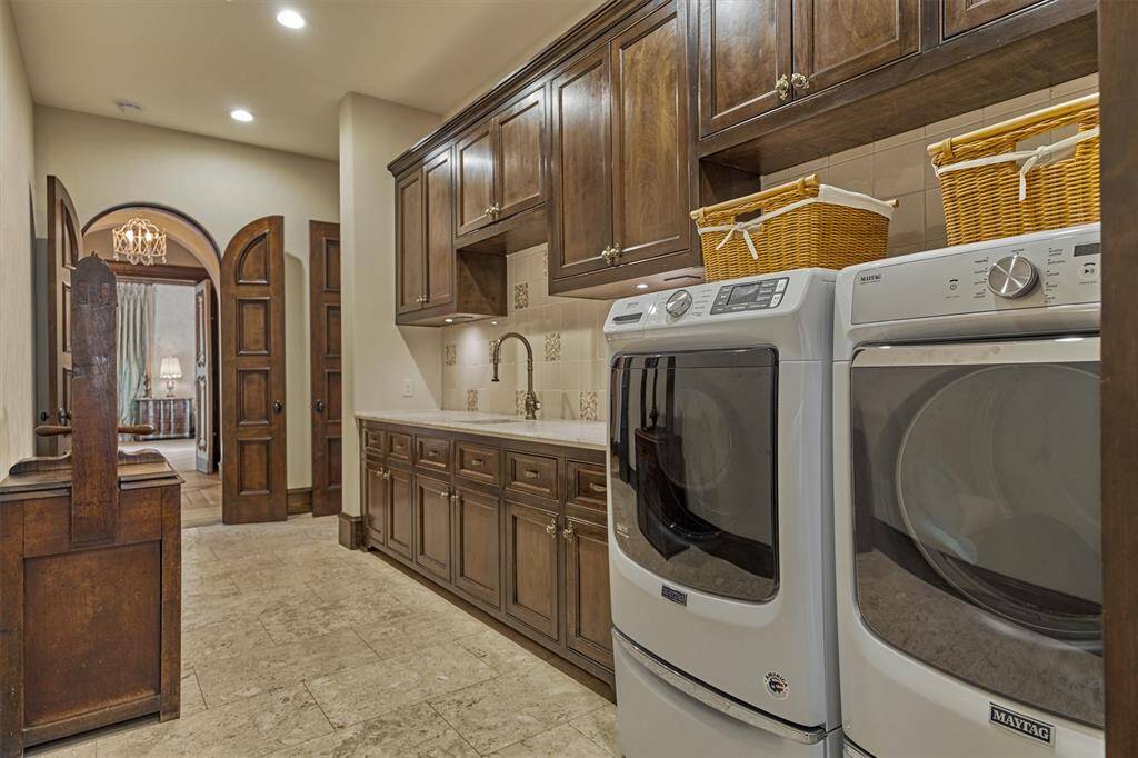 Thoughtfully positioned laundry room connects to both the primary suite and hallway off the kitchen. full-length countertop for added workspace.  Marvelous tile backsplash , with flooring imported from  Israel.
