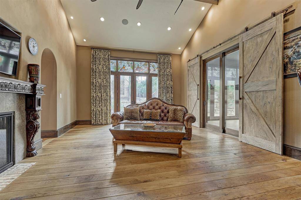 Glass doors in family room provide access to the classic car restoration workshop, blending luxury living with automotive passion.