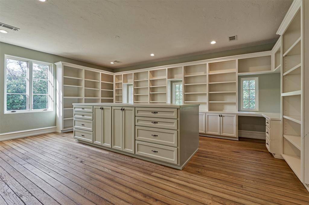 An enormous upstairs bonus room offers endless possibilities, featuring abundant built-ins and oversized central island for versatile use as wrap room, craft room, or your own creative haven.