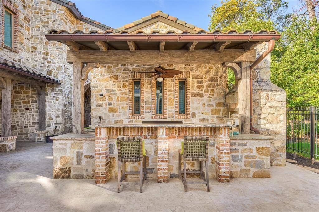 Outdoor kitchen blends rustic charm with modern functionality. Featuring a built-in gas pizza oven, it offers the perfect setup for al fresco dining and entertaining.